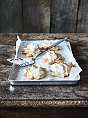 Meringues and cream on a baking tray