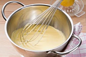 Sauce Hollandaise with a whisk in a pot