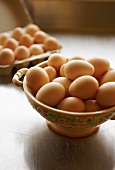 Frische Eier in einer Keramikschale und im Eierkarton
