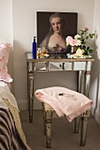 Barockes Damenportrait, Parfumflakons und Rosenblüten auf antikem, verspiegeltem Wandtisch mit passendem Hocker