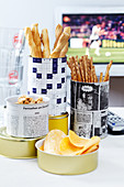 Snacks in tin cans decorated with newspaper