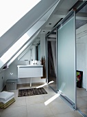Modernes Bad mit Waschtisch und Abtrennung mit leichter Schiebeelementkonstruktion in ausgebautem Dach