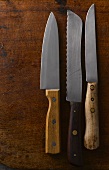 Drei alte Messer auf Holzuntergrund