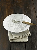 A fork on a ceramic plate on a linen napkin