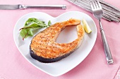 A salmon steak on a heart-shaped plate