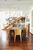 Moderner Esstisch und Schalenstühle aus Holz in offenem Wohnraum