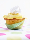 A lemon and rosemary cupcake topped with a dollop of cream
