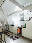 Modern kitchen below old roof beams