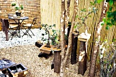 Gestalteter Garten mit Bonsai-Bäumen und Sitzecke