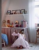 Girl on knees searching in cupboard