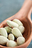 Fresh almonds on a wooden ladle