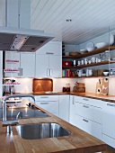 White kitchen with wooden work surfaces on island and base units