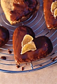 Heart-shaped ginger and chocolate biscuits on a wire rack (close-up)