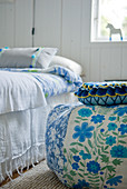 Beanbag with floral cover next to bed in rustic room