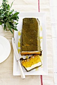 Cheese and pumpkin terrine with walnuts wrapped in vine leaves