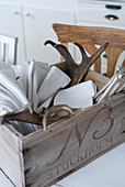 Linen napkins and antlers in vintage wooden crate