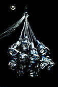 Bunch of industrial spotlights as pendant lamp hanging from black ceiling