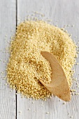 A pile of couscous with a wooden spoon