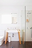 Freistehender Waschtisch mit Wandarmatur und Spiegel neben Duschtrennwand