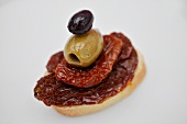 Pane e salame (a slice of bread topped with dried tomatoes and olives)