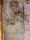 Coloured prints of various types of flower hanging on vintage wall with peeling paint
