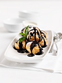 Profieroles with chocolate sauce and mint
