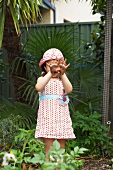 Little girl showing hands dirtied by gardening