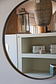 Decorative, Oriental metal boxes on shelves reflected in round mirror