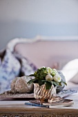 White ranunculus in silver pot on coffee table