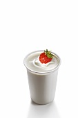 A strawberry in a pot of yogurt