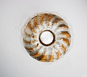 A Bundt cake dusted with icing sugar, seen from above