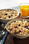 Two Bowls of Puffed Rice Cereal with Fresh Blueberries and Orange Juice
