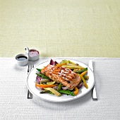 Marinated, grilled salmon on a bed of stir-fried vegetables