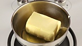 Grosses Stück Butter in einem Topf beginnt zu schmelzen