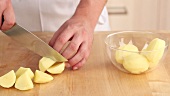 Peeled potatoes being quartered