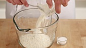 Flour being poured into a bowl