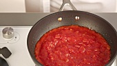 Tomatensauce in einer Pfanne köcheln lassen