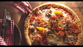 Vegetarische Pizza, Hand entnimmt ein Stück