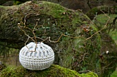 Contorted willow in spherical vase with crocheted cover