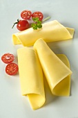 Rolls of cheese with cherry tomatoes and a chervil leaf