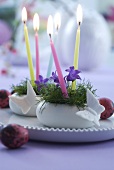 Kleine Ostergestecke mit Glockenblumen und Kerzen