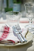 A place setting with a napkin and a drinking glass
