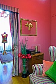 Kräftige Farben in Wohnzimmerecke - Lesesessel mit gestreiftem Bezug vor offenem Durchgang mit gerafftem Vorhang und Blick auf Schneiderpuppe