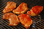 Five Marinated Boneless Pork Chops on a Charcoal Grill