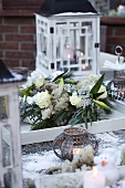 Winter wreath with roses and lilies, lanterns and tea light holders