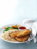 Breaded chicken fillets with rice and a side of vegetables