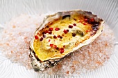 A gratinated oyster with pink pepper