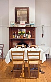 Gedeckter Restauranttisch; im Hintergrund ein offener Kamin mit Holzeinfassung und einem antiken Wandspiegel darüber