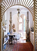 Eye catching kitchen in a mix of styles with vintage stove, iron table and chairs and decorative columns