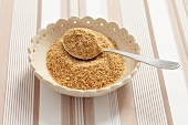 Ground flax seeds in a spoon with a spoon